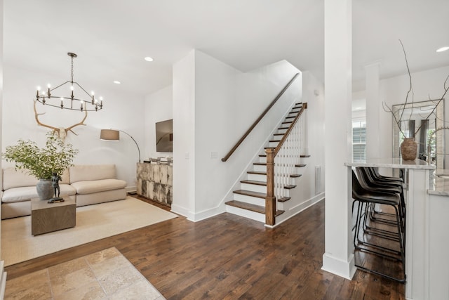 stairs featuring hardwood / wood-style floors and a notable chandelier