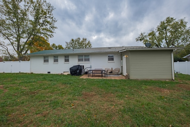 rear view of house featuring a lawn and a patio area