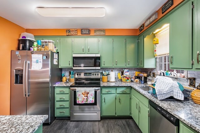 kitchen with green cabinets, decorative backsplash, stainless steel appliances, and dark hardwood / wood-style flooring