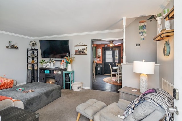 carpeted living room with ceiling fan, ornamental molding, and a fireplace