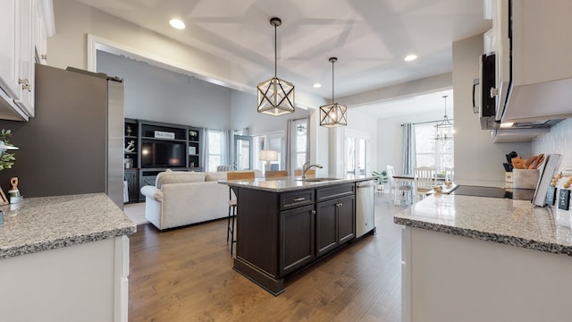 kitchen featuring stainless steel appliances, white cabinetry, dark hardwood / wood-style floors, a kitchen island with sink, and pendant lighting