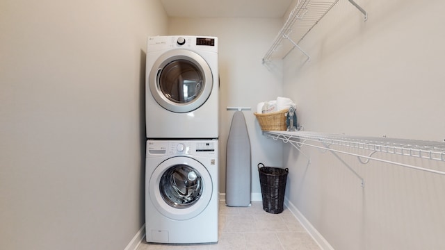 laundry room with stacked washer and dryer and light tile patterned floors