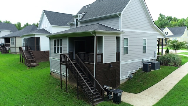 back of property with central air condition unit and a yard