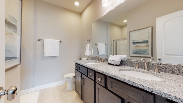 bathroom with vanity, a shower with door, tile patterned floors, and toilet