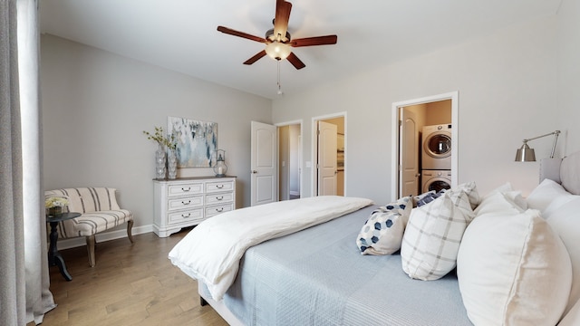 bedroom with ceiling fan, wood-type flooring, ensuite bath, and stacked washer / dryer