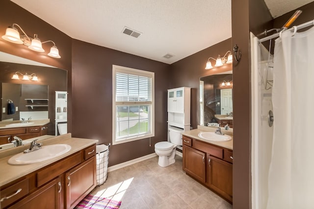 bathroom with toilet, vanity, a textured ceiling, and curtained shower