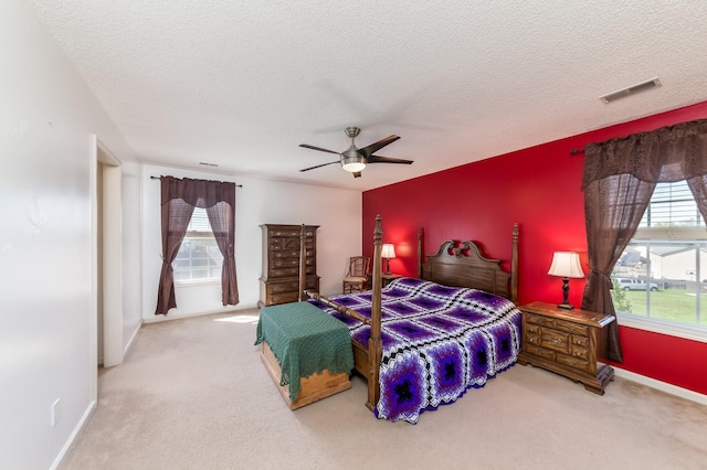 carpeted bedroom with a textured ceiling and ceiling fan