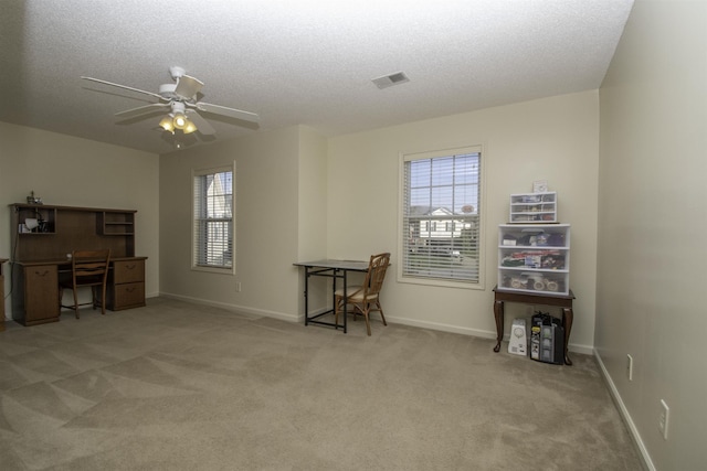 miscellaneous room featuring a textured ceiling, light colored carpet, and ceiling fan