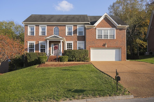 colonial home featuring a front yard and a garage