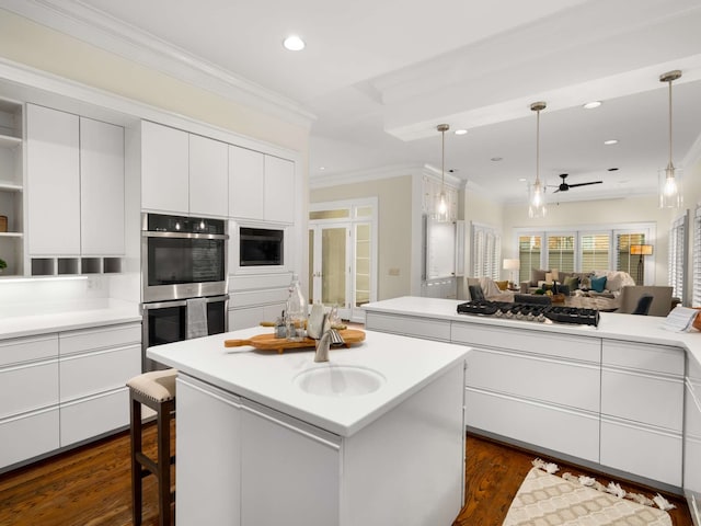 kitchen featuring ceiling fan, stainless steel double oven, a center island, white cabinets, and dark hardwood / wood-style flooring