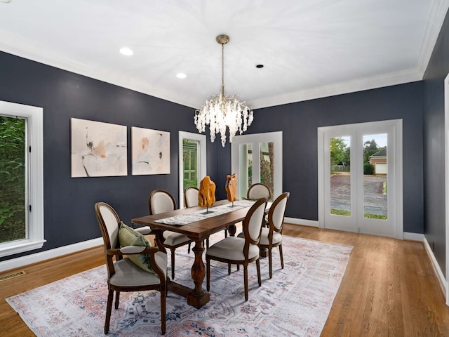 dining room with a notable chandelier, hardwood / wood-style flooring, and crown molding