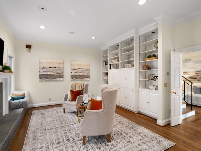 living area featuring hardwood / wood-style flooring and ornamental molding