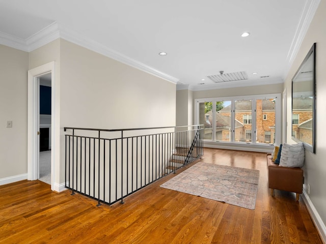 hall with hardwood / wood-style flooring and crown molding