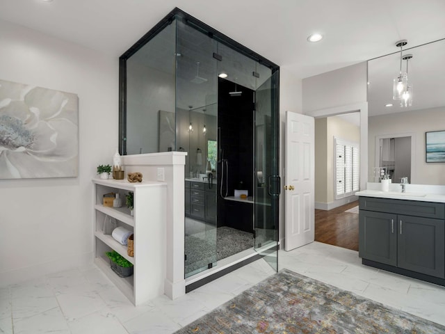 bathroom featuring a shower with door and vanity