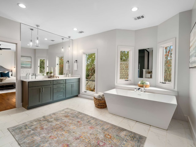 bathroom with a washtub, vanity, and hardwood / wood-style floors