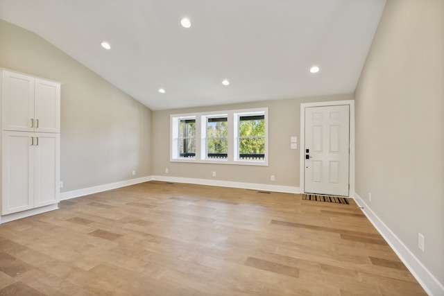 interior space with light hardwood / wood-style floors and lofted ceiling