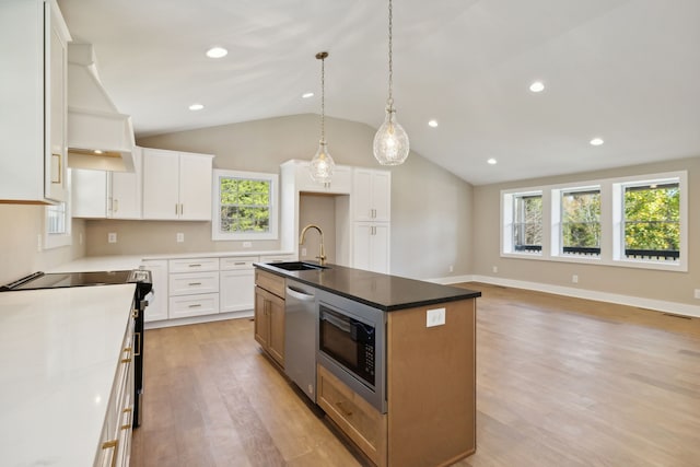 kitchen featuring white cabinetry, a wealth of natural light, and a center island with sink