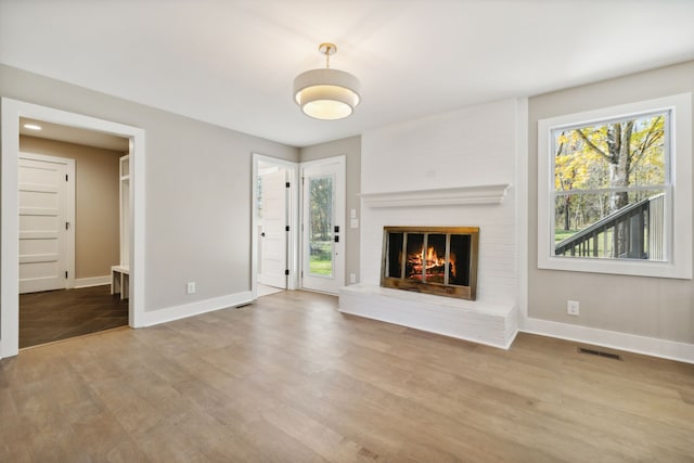 unfurnished living room with light wood-type flooring and a fireplace