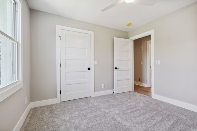 unfurnished bedroom featuring ceiling fan and light colored carpet