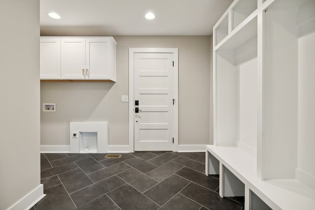 laundry area with dark tile patterned flooring, hookup for a washing machine, electric dryer hookup, and cabinets