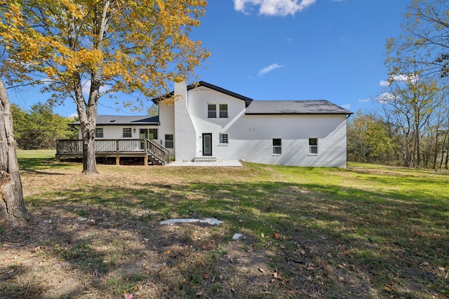 rear view of property with a lawn and a wooden deck