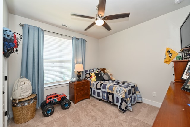 carpeted bedroom featuring multiple windows and ceiling fan