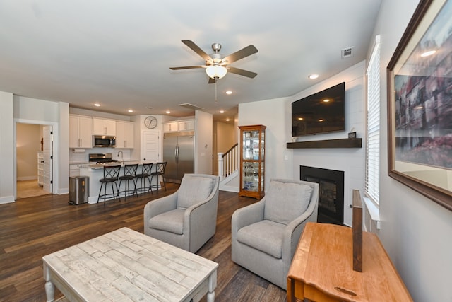 living room with dark wood-type flooring, a wealth of natural light, sink, and ceiling fan