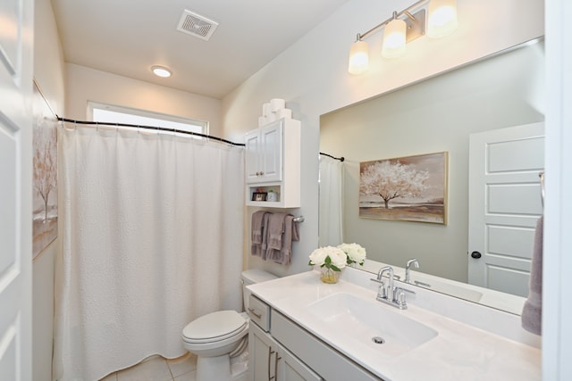 bathroom with toilet, vanity, and tile patterned floors