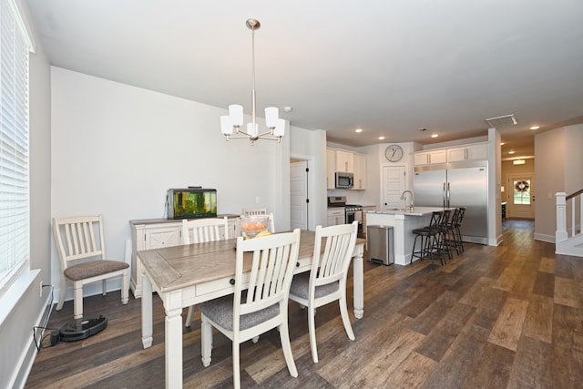 dining room featuring sink, dark hardwood / wood-style flooring, and a notable chandelier