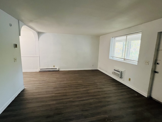 spare room featuring a wall mounted air conditioner, a baseboard radiator, and dark hardwood / wood-style floors