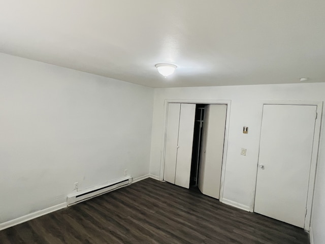 unfurnished bedroom featuring dark wood-type flooring and a baseboard radiator