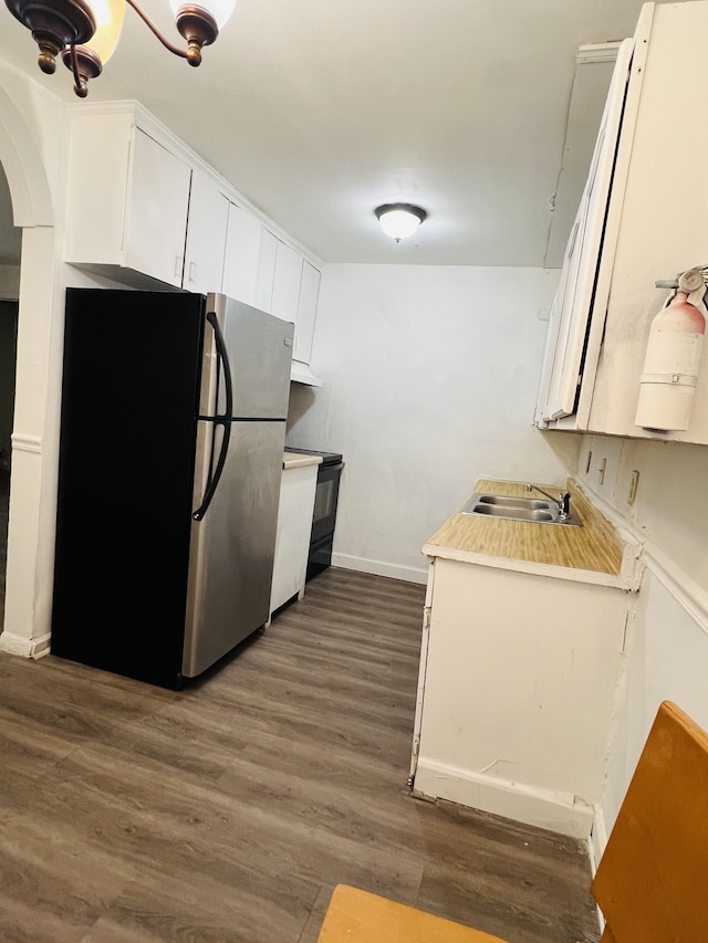 kitchen with white cabinets, stainless steel fridge, dark hardwood / wood-style floors, and sink