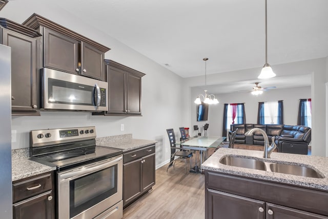 kitchen featuring sink, stainless steel appliances, light hardwood / wood-style flooring, pendant lighting, and dark brown cabinets