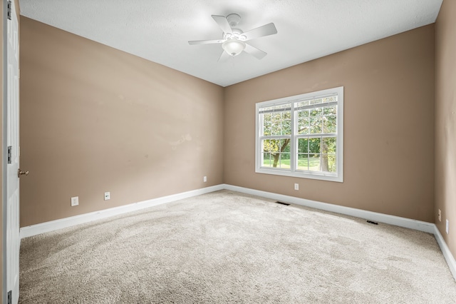 unfurnished room with carpet flooring, a textured ceiling, and ceiling fan