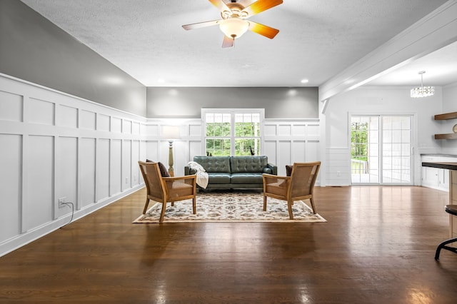 living room featuring dark hardwood / wood-style floors, a textured ceiling, and ceiling fan with notable chandelier