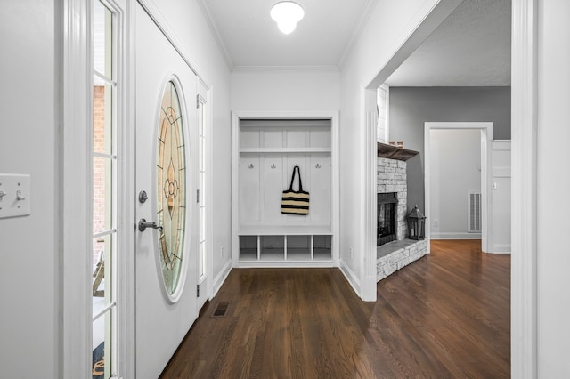 interior space with a fireplace, dark wood-type flooring, a textured ceiling, and crown molding