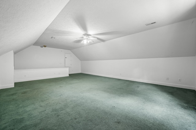 additional living space featuring ceiling fan, a textured ceiling, vaulted ceiling, and dark carpet