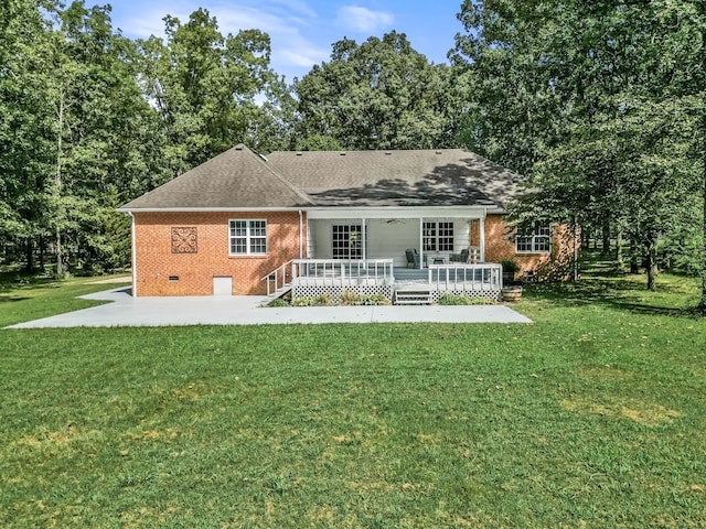 back of house featuring a deck, a lawn, and a patio area