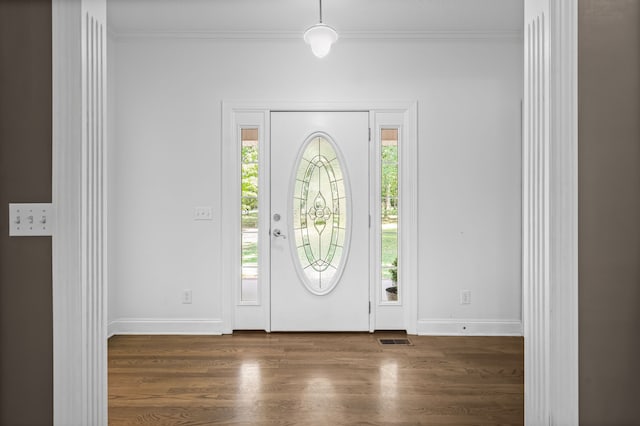 entryway with dark hardwood / wood-style floors and crown molding