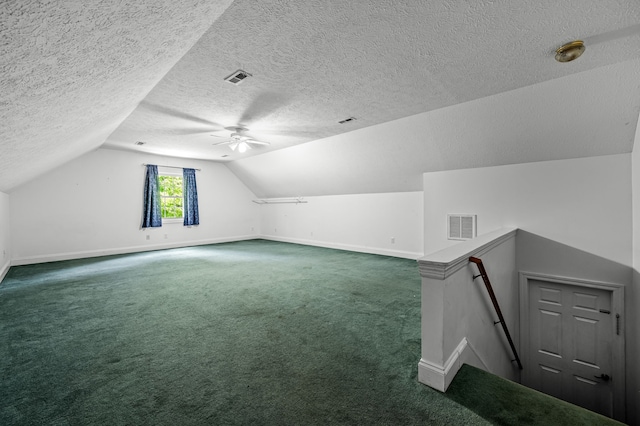 additional living space with ceiling fan, dark colored carpet, a textured ceiling, and vaulted ceiling