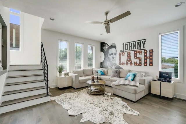 living room with dark wood-type flooring and ceiling fan