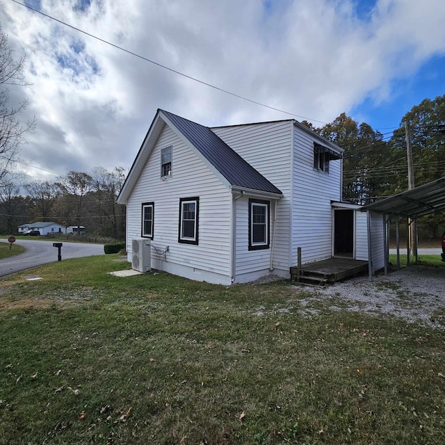 view of side of home featuring a carport and a yard