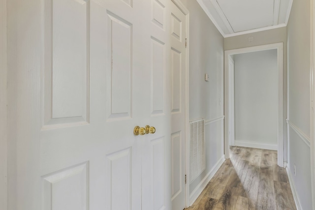 hallway featuring hardwood / wood-style flooring and crown molding