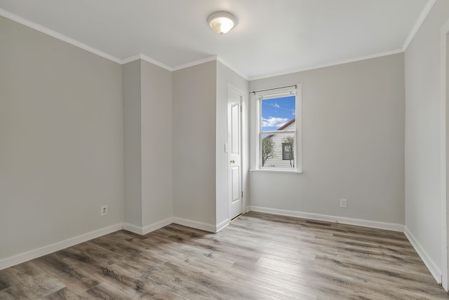 empty room featuring crown molding and light hardwood / wood-style flooring