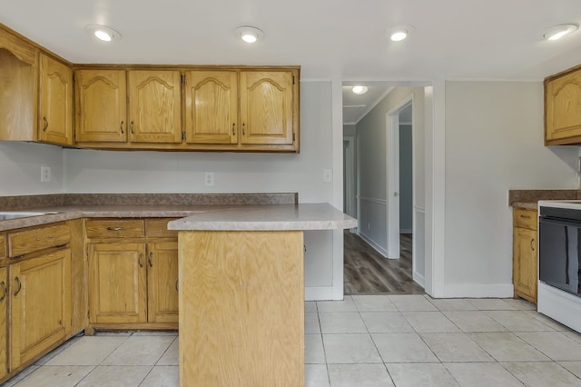 kitchen with ornamental molding, light tile patterned floors, kitchen peninsula, and white range oven