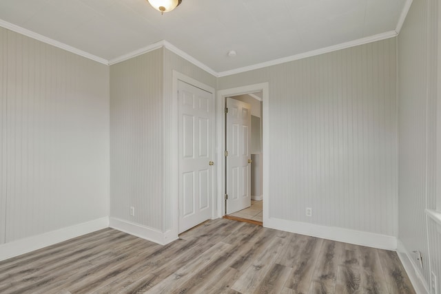 unfurnished room featuring ornamental molding and light wood-type flooring