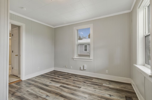 spare room with hardwood / wood-style floors and crown molding