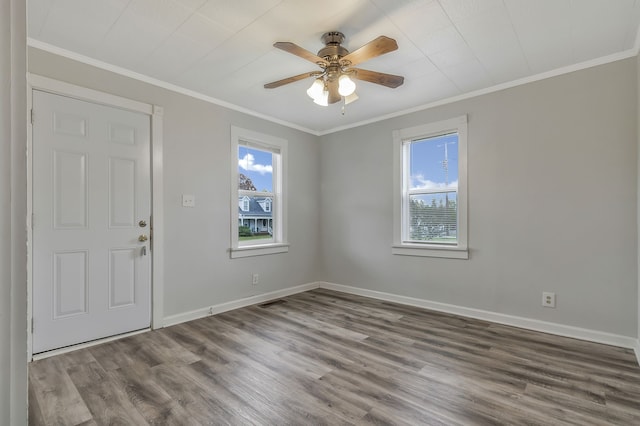 entrance foyer with hardwood / wood-style floors, a wealth of natural light, and crown molding