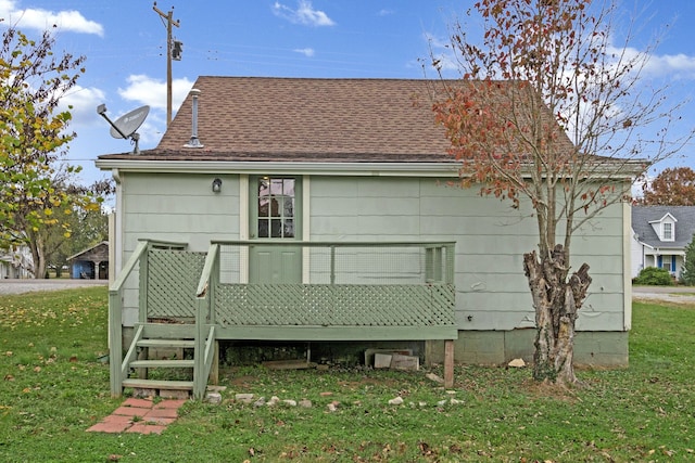 back of house with a deck and a yard