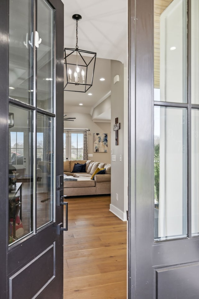 interior space featuring hardwood / wood-style flooring, an inviting chandelier, and vaulted ceiling